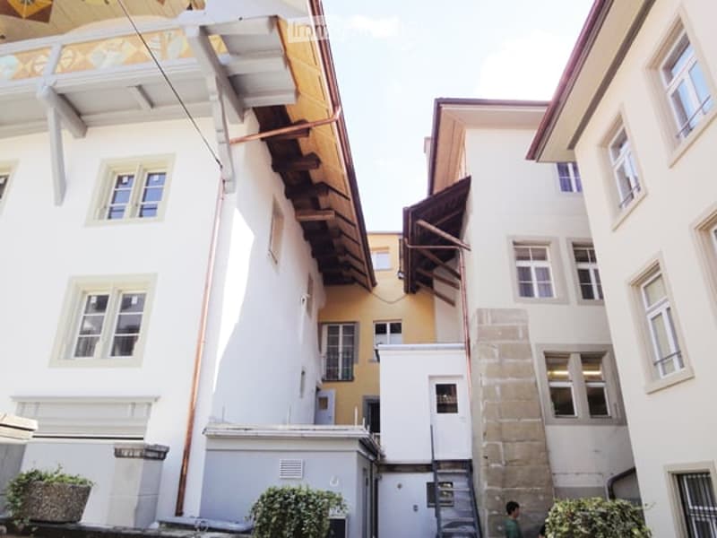 Multi-story residential buildings, yellow painted walls, balconies with metal railings, modern and traditional architectural styles
