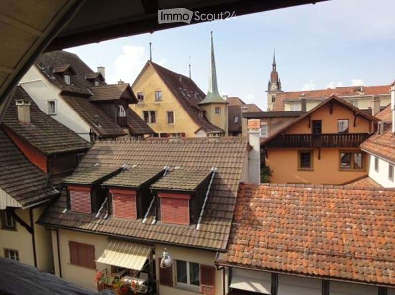 aerial view of an old town with several buildings, steeple and spire, clear sky, roofs