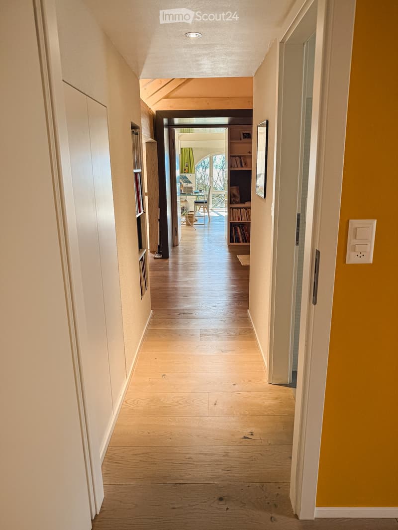 wooden floor, yellow wall, white wall, wooden shelves, picture frame, open door, hallway light