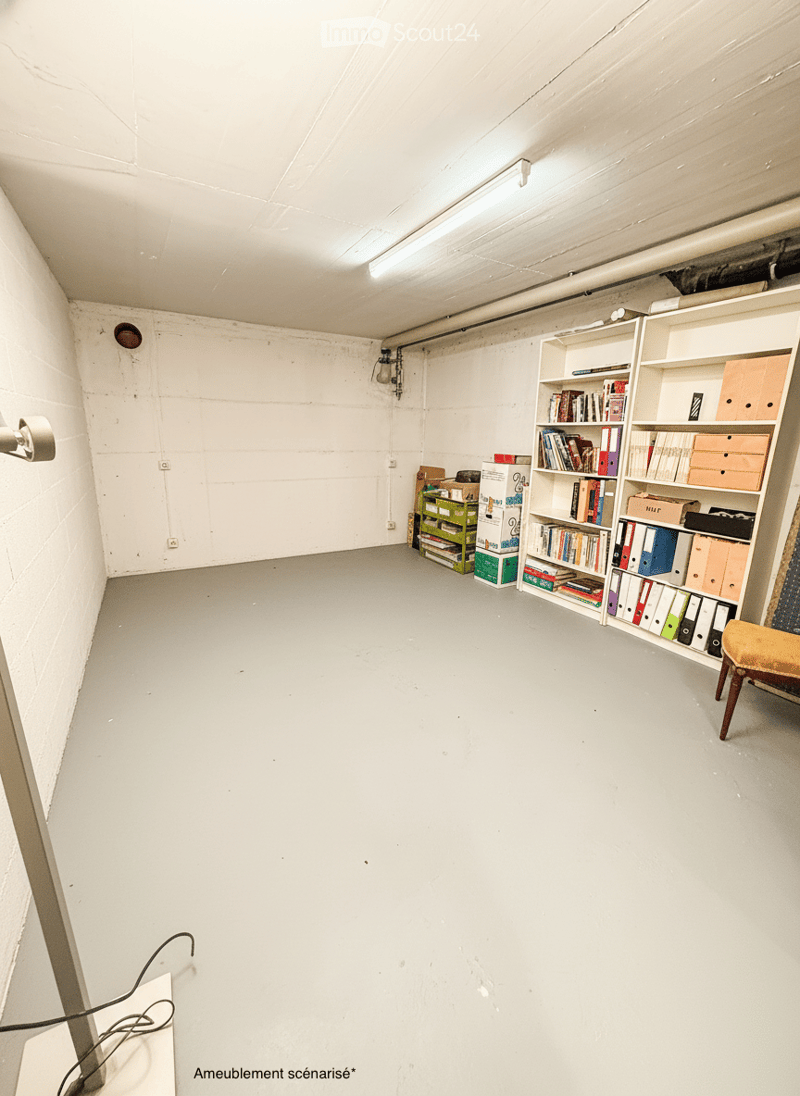 Empty room with white walls, gray floor, white shelves, and a chair