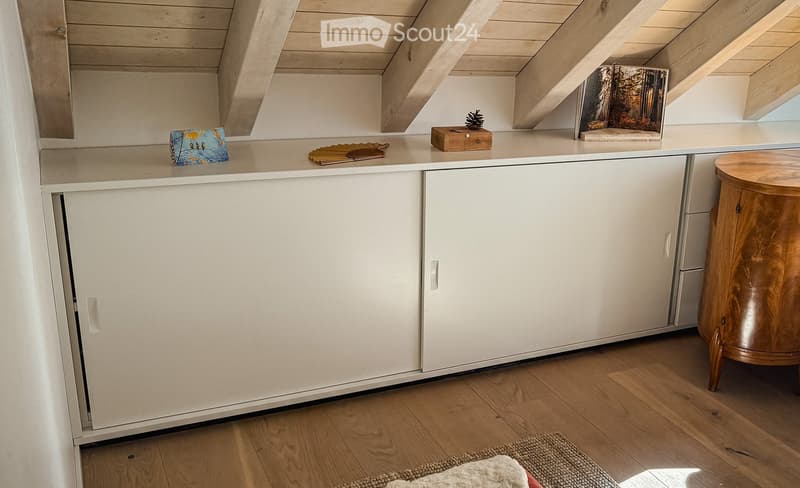 white cabinets, wooden floor, wooden beams, small wooden table, rug, decorative items