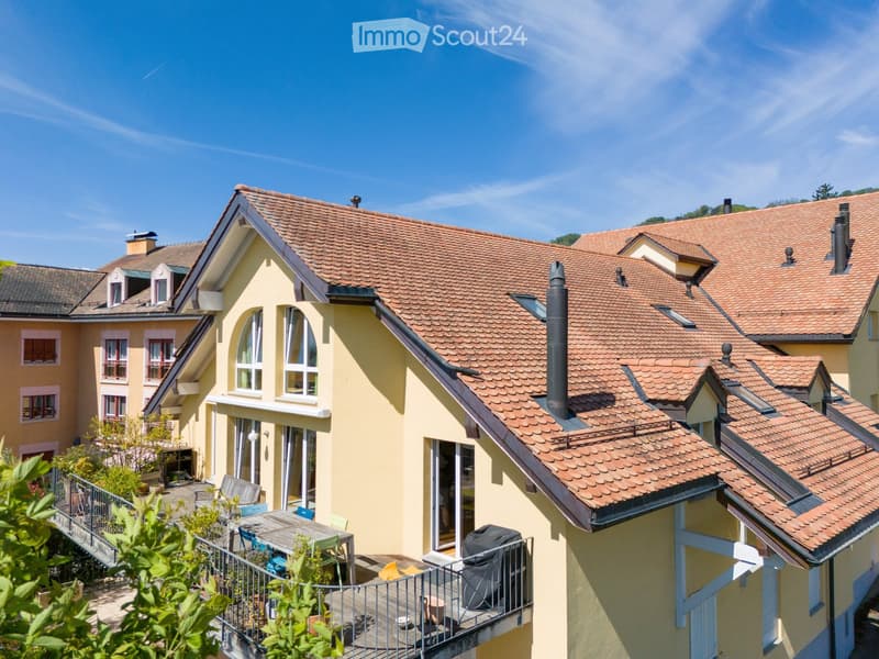 2 story house, yellow exterior, brown roof, balcony, windows, garden, table, chairs