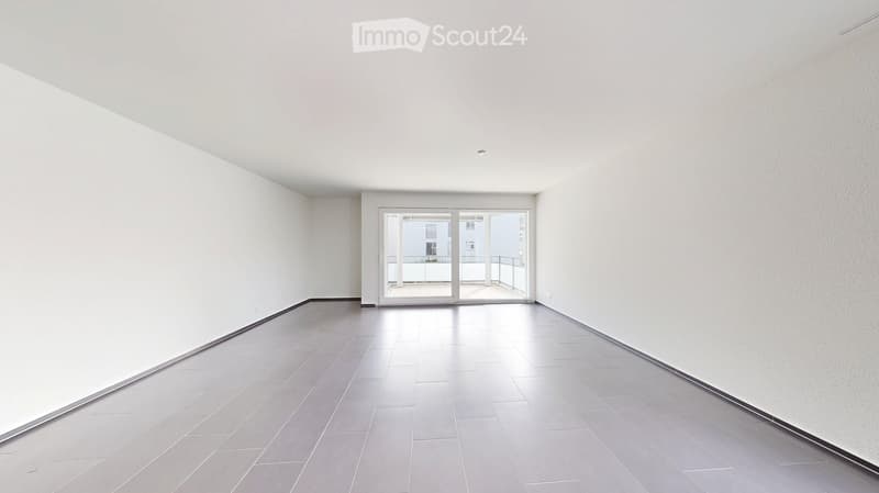empty room with white walls and gray floor, sliding doors to a balcony
