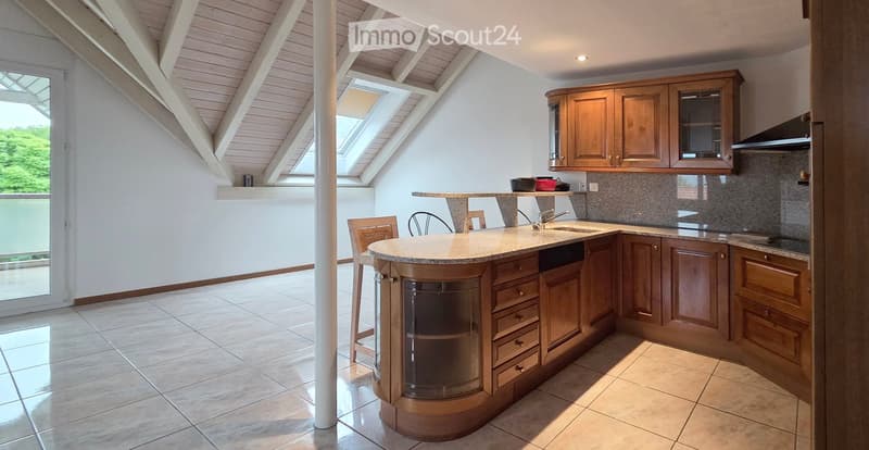 Bright kitchen with wooden cabinets, a central island, and a sink, featuring large windows and skylights.
