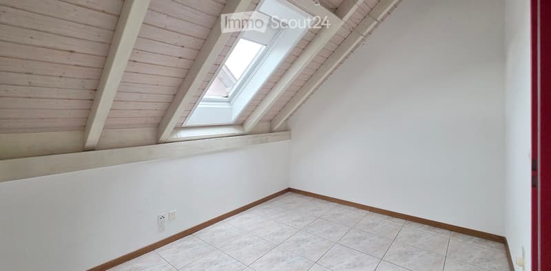 Empty room with white walls, tiled floor, wooden trim, and skylight windows.