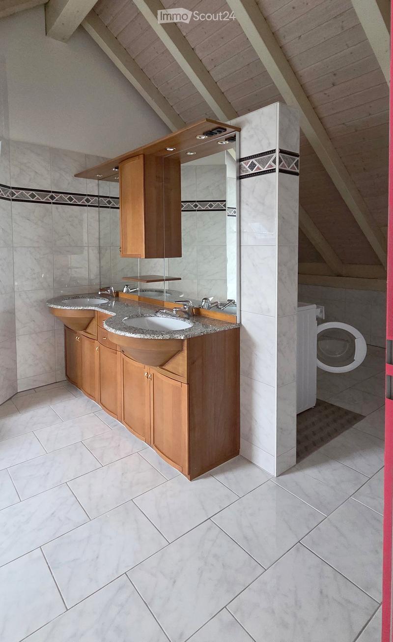 Modern bathroom with double sink vanity, wooden cabinets, granite countertop, and built-in washing machine.