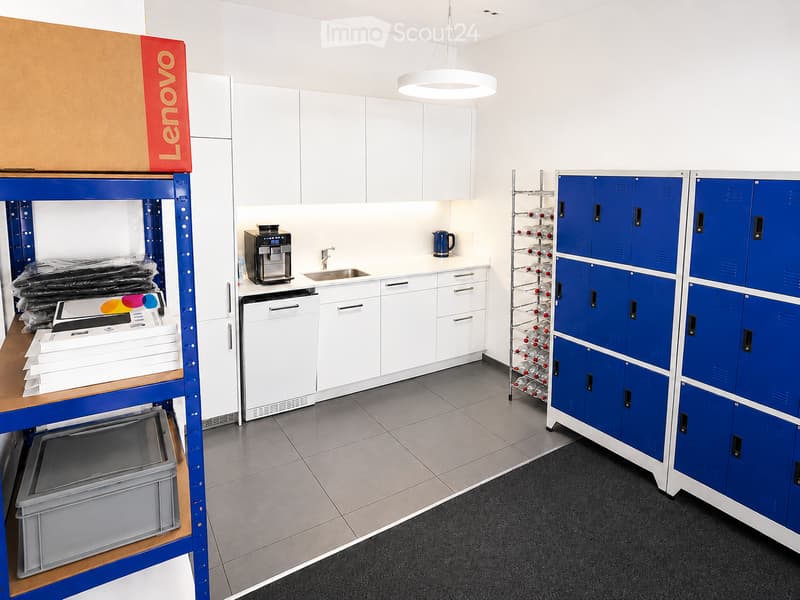 Break room with white cabinets, coffee machine, sink, wine rack, and blue lockers.