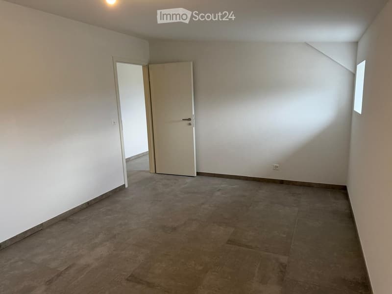 Unfurnished Room. Empty room with beige walls, tiled floor, and a single door leading to another space.