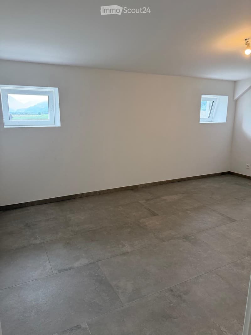Unfurnished Room. Empty room with tiled floor and two windows, one offering a view of a landscape.