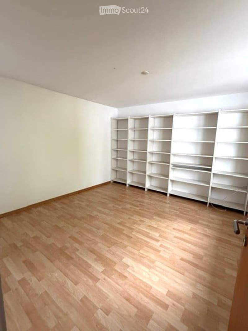 Unfurnished Room. Empty room with wooden flooring and white built-in shelving units along one wall. No furniture or personal items present.