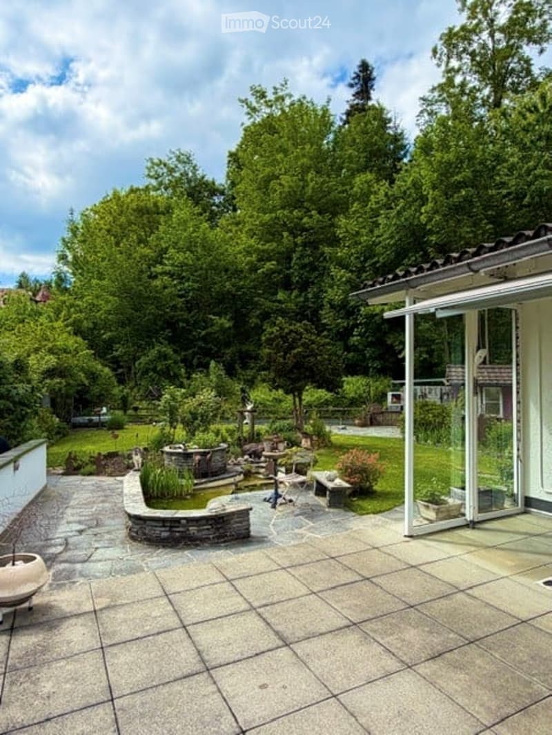 Garden / Outdoor Area. Well-maintained garden with a stone pathway, small pond, seating area, and lush greenery.