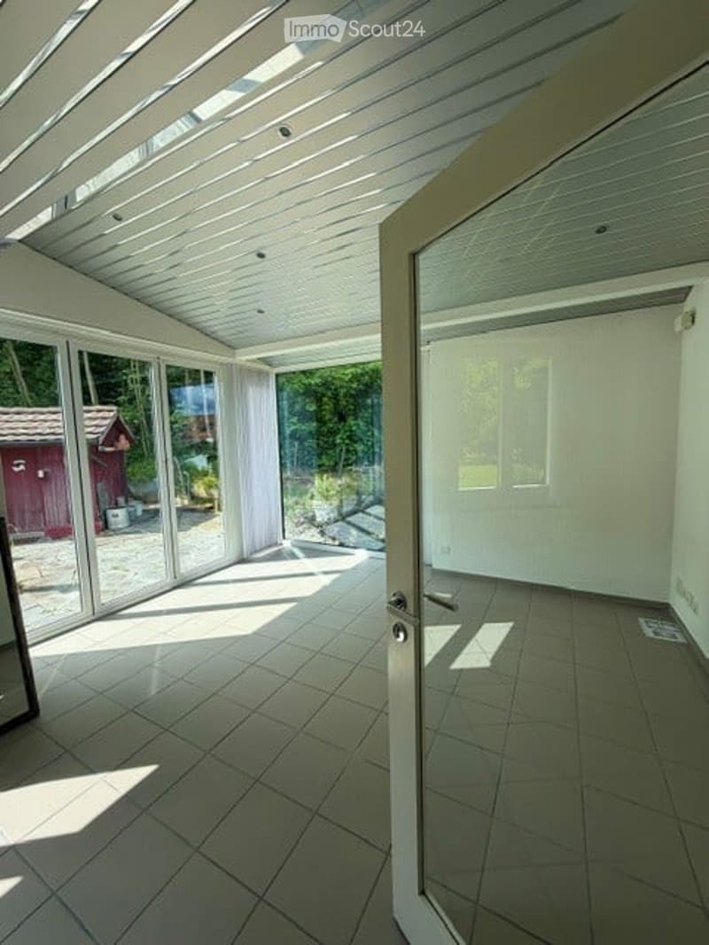 Unfurnished Room. Bright, empty room with large glass walls and a tiled floor, connected to an outdoor area.