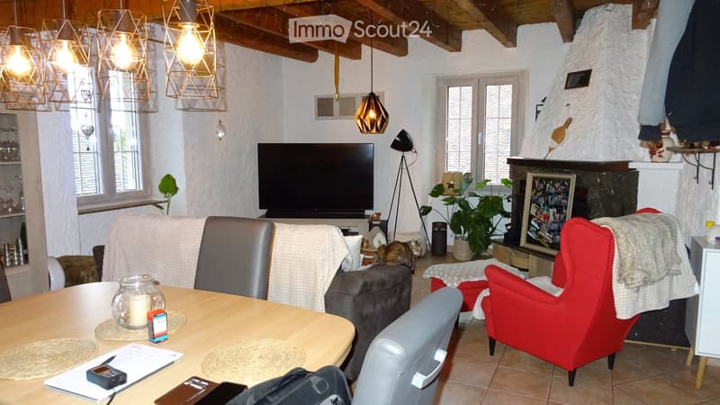 large sofa, fireplace, two chairs, dining table, windows, large TV