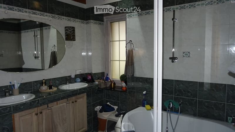 Green and white tiled, double sink, walk-in shower, bathtub