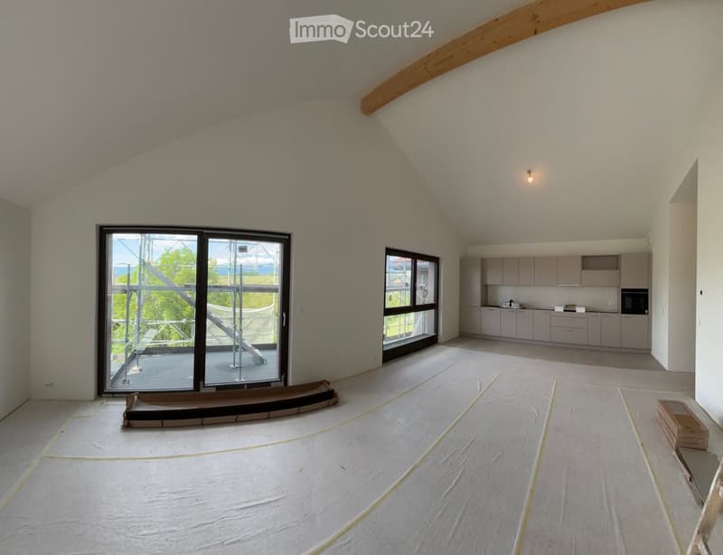 Furnished Room. Open-plan space with exposed wooden beams, large windows, and a fitted kitchen area with cabinets and an oven. The floor is covered with protective sheeting.