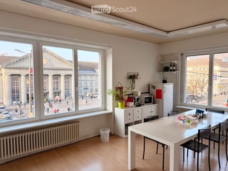 large open room, dining table, chairs, cabinets, desk, microwave, radiator