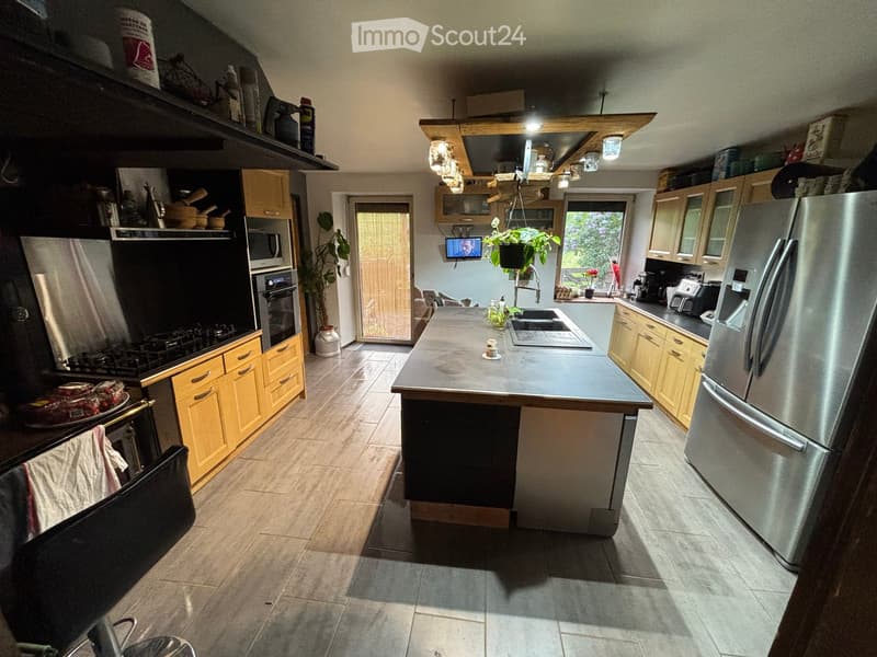 Kitchen. Modern kitchen with stainless steel appliances, wooden cabinets, island, and a view to the outside.