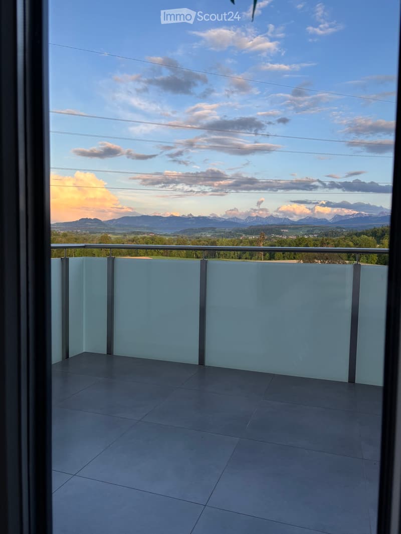 Balcony / Terrace. Modern balcony with a glass railing, tiled floor, and scenic mountain view.