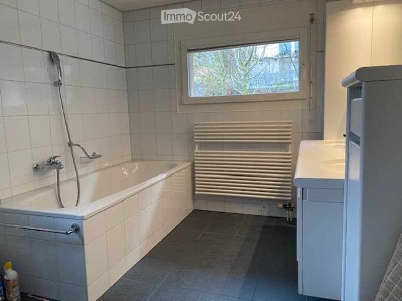 bathroom with bathtub, shower, radiator, sink, white tiles, small window