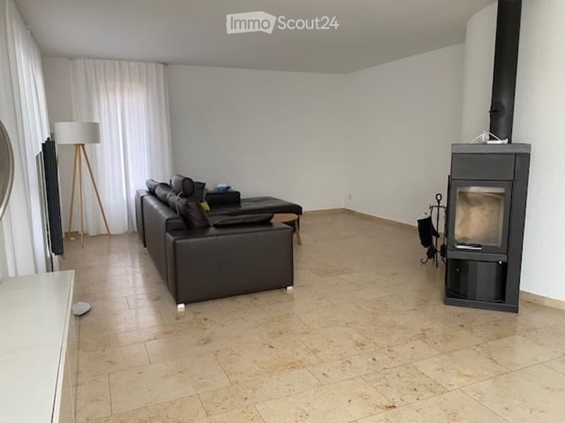 leather sofa, wooden coffee table, TV, fireplace, wooden lamp, large tiled floor, white walls, large windows