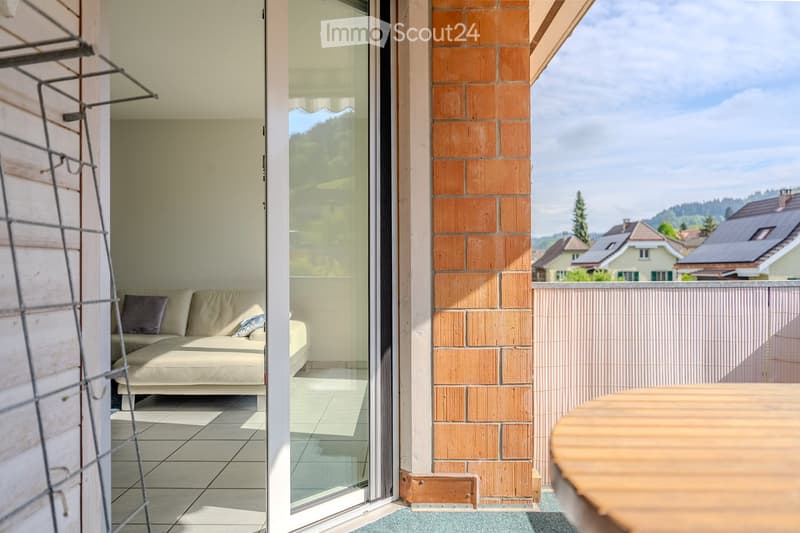 Balcony with a view of the surrounding landscape, featuring a sofa and a table.