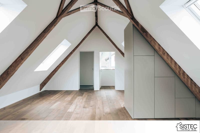 attic with wooden beams, wooden floor, gray walls, three windows