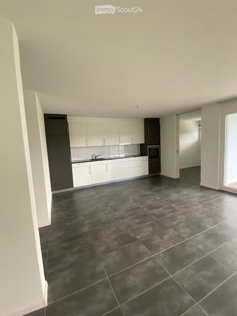 Kitchen. Modern kitchen with white cabinets, dark grey tiles, and stainless steel appliances including a sink and oven.