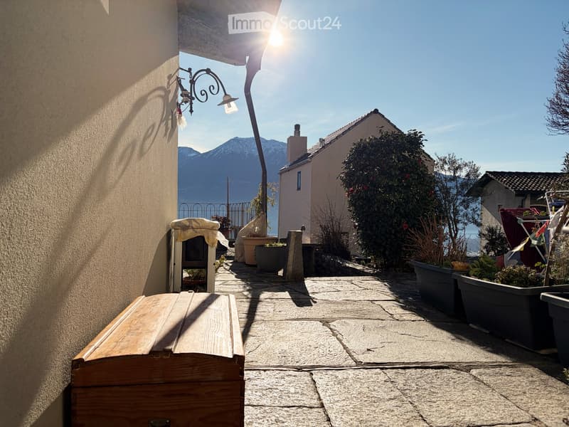 stone pathway leading to the back of the house, small bench, plants, mountain view, sunny