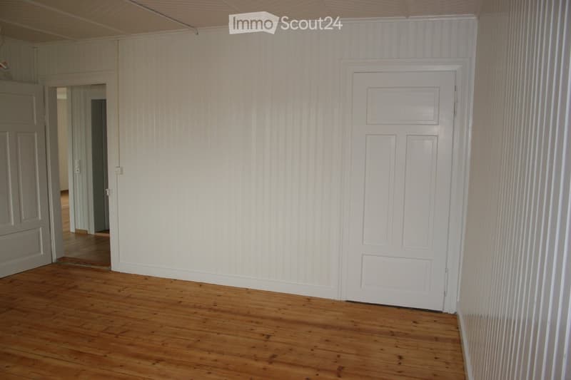 empty room, wooden floor, white walls, two doors