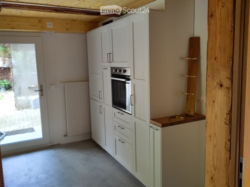 Kitchen. Modern kitchen with white cabinets, stainless steel oven, wooden shelves, and a glass door.