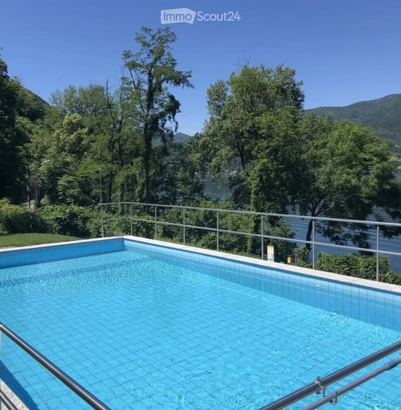 Garden / Outdoor Area. Swimming pool with a scenic view of a lake and surrounding greenery.