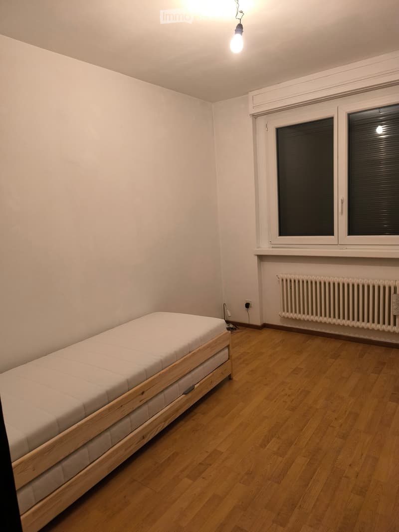 Bedroom. Minimalist bedroom with a single wooden bed, light-colored bedding, wooden flooring, and a window with blinds.