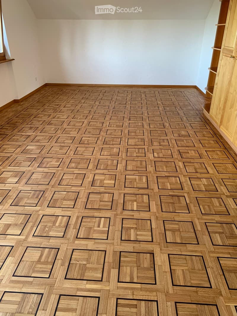 Unfurnished Room. Completely empty room with a patterned wooden floor and white walls. No furniture or equipment is present.