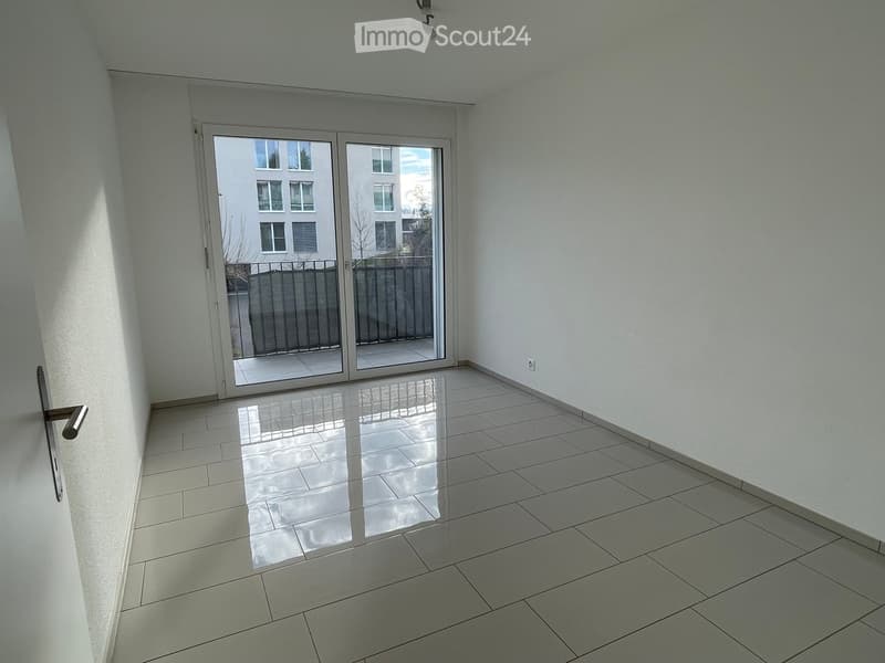 empty room, sliding glass doors leading to balcony, white tile floor, white walls