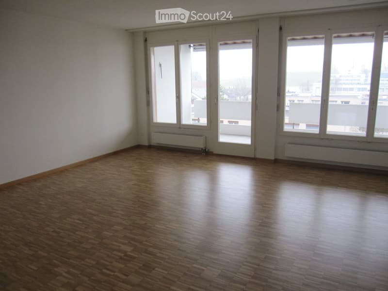 Unfurnished Room. Empty room with wooden flooring, large windows, and radiators along the walls.