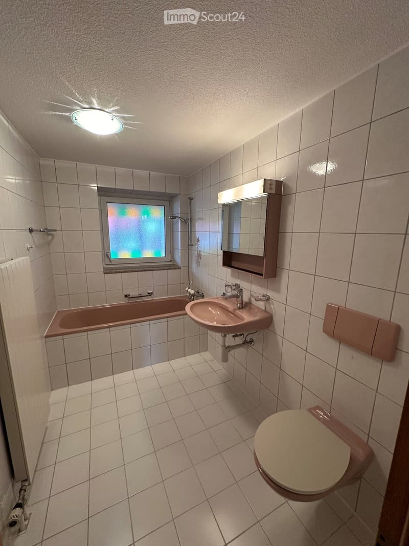 Bathroom. Bathroom with tiled walls and floor, featuring a bathtub, sink, toilet, mirror, and showerhead.