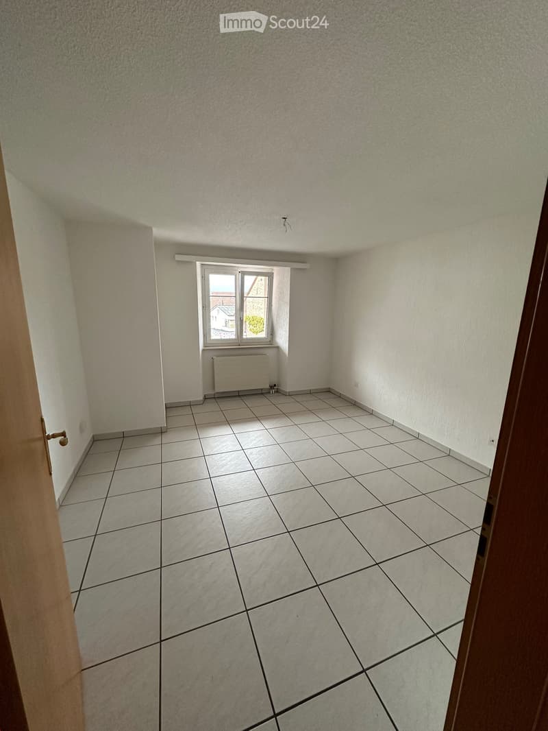 Unfurnished Room. Empty room with tiled floor, white walls, a window, and a radiator. No furniture or equipment present.