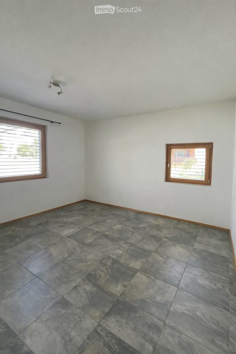 Unfurnished Room. Empty room with grey tiled floor, white walls, and two windows with wooden frames and blinds.