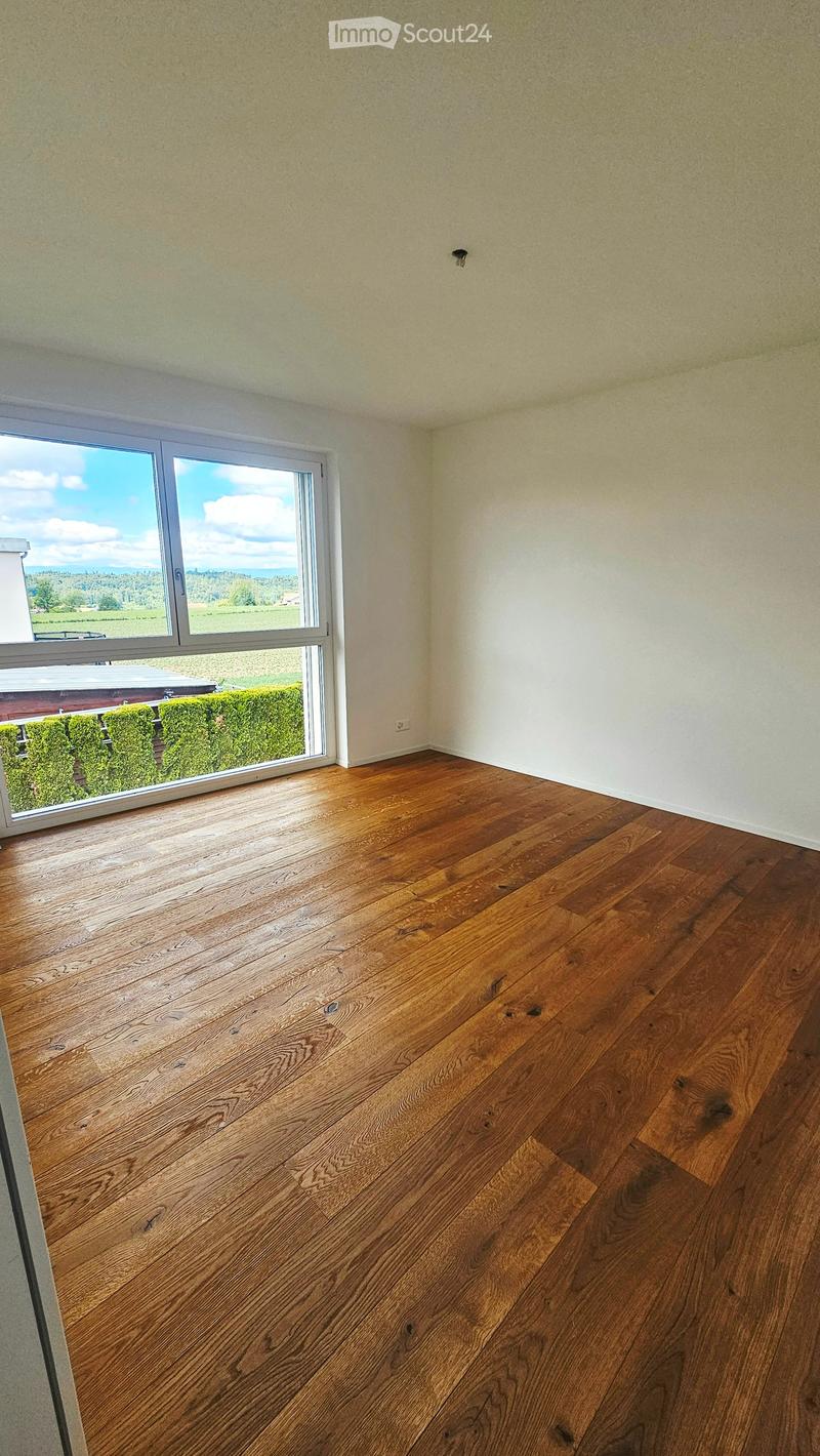 Unfurnished Room. Empty room with wooden flooring and large windows offering a view of the outdoors.