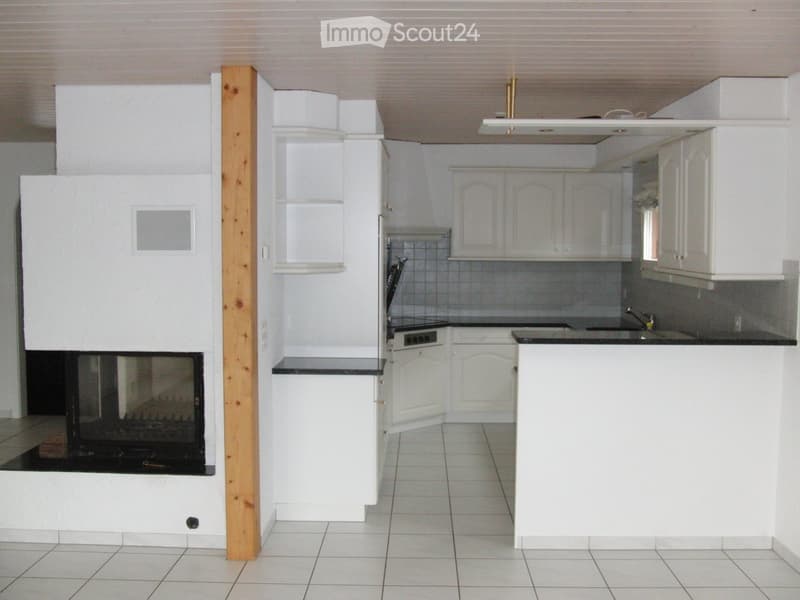 modern kitchen, fireplace, white cabinets, tile flooring, black countertops