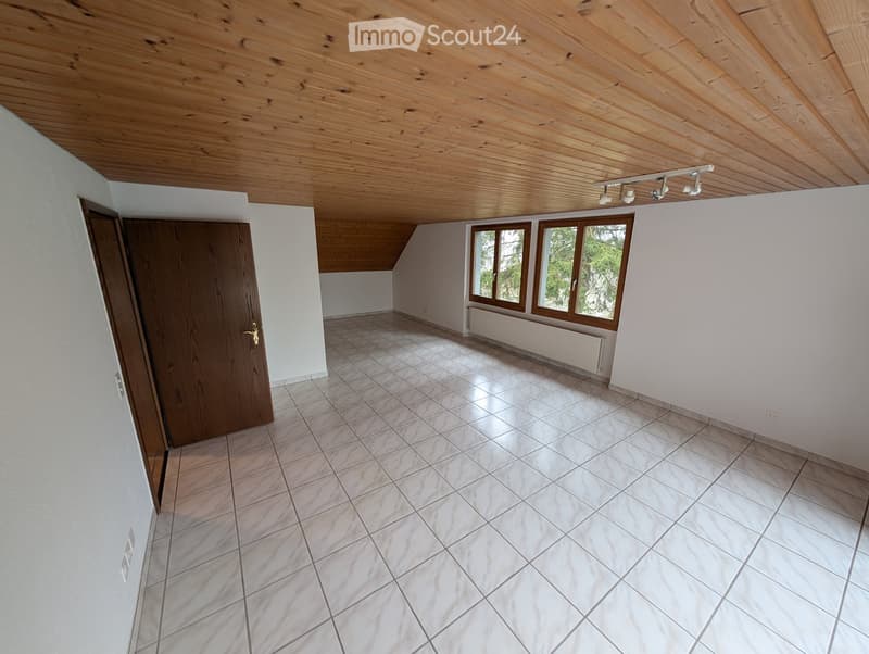 Unfurnished Room. Empty room with white walls, tiled floor, wooden door, and large windows with wooden frames. The ceiling is wooden with exposed beams and track lighting.