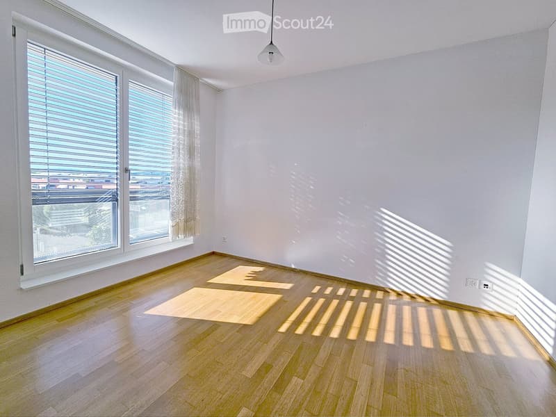 Unfurnished Room. Empty room with wooden flooring, large windows with blinds, and natural light streaming in. No furniture or equipment present.