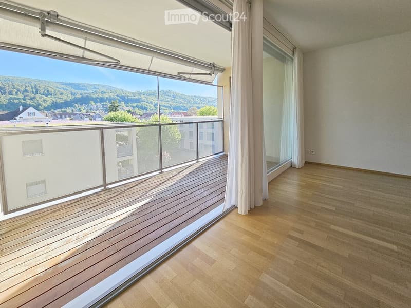 Unfurnished Room. Empty room with wooden flooring, large windows, and a wooden balcony with a glass railing.