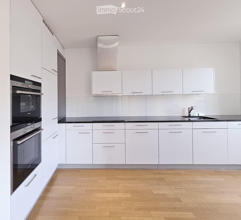 Kitchen. Modern kitchen with white cabinets, stainless steel oven, and wooden flooring.