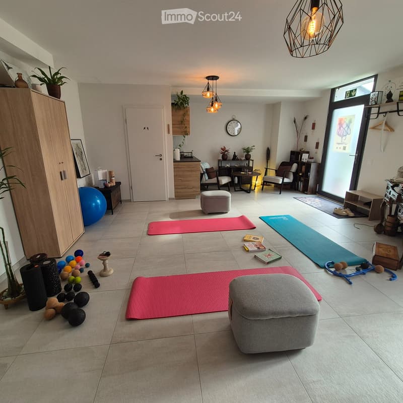 Furnished Room. Well-lit living room with tiled floor, modern decor, yoga mats, exercise balls, and a comfortable sofa.
