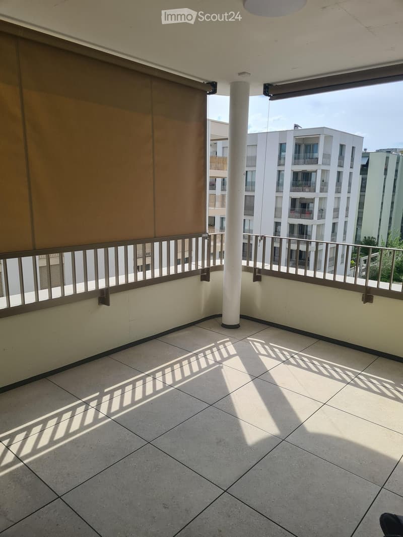 Balcony / Terrace. Empty balcony with tiled floor, metal railing, and a view of neighboring buildings.