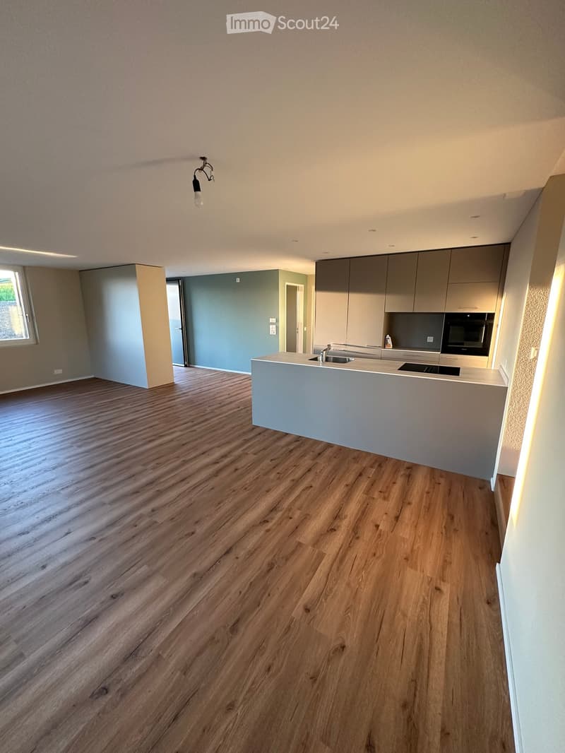 Unfurnished Room. Empty kitchen with wooden flooring, modern cabinets, and a central island. No furniture or appliances are present.
