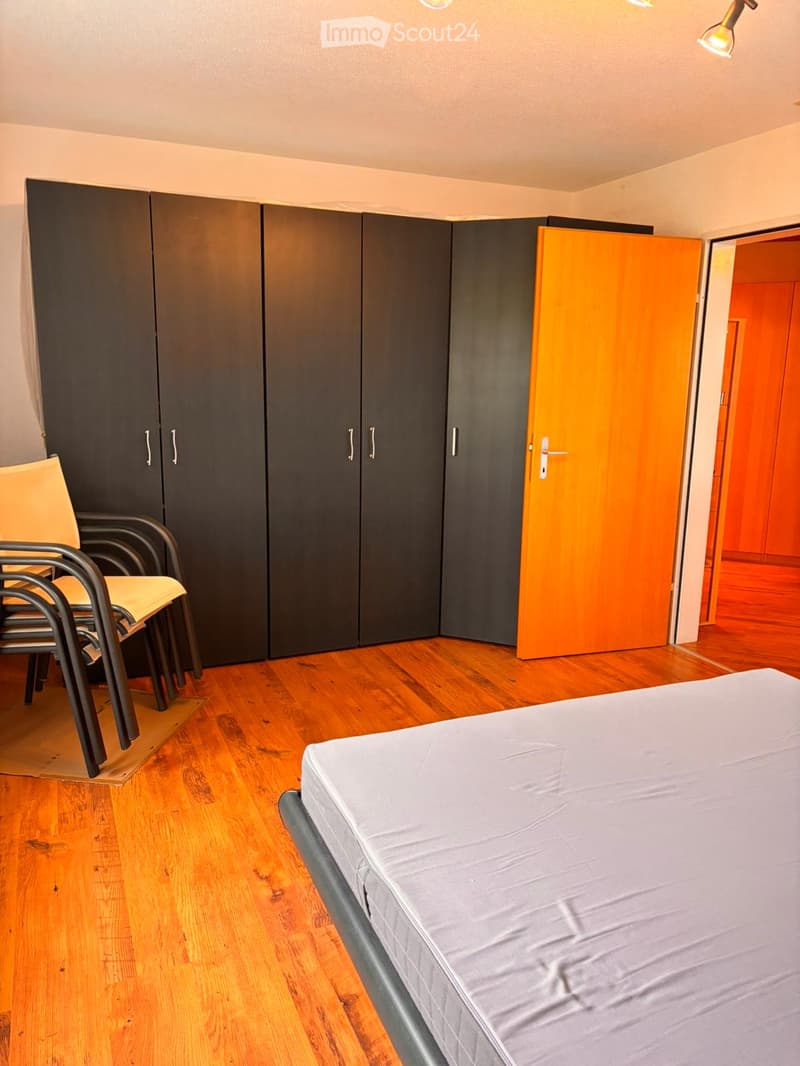Bedroom. Bedroom with wooden flooring, a single bed, a chair, and a large wardrobe with multiple doors.