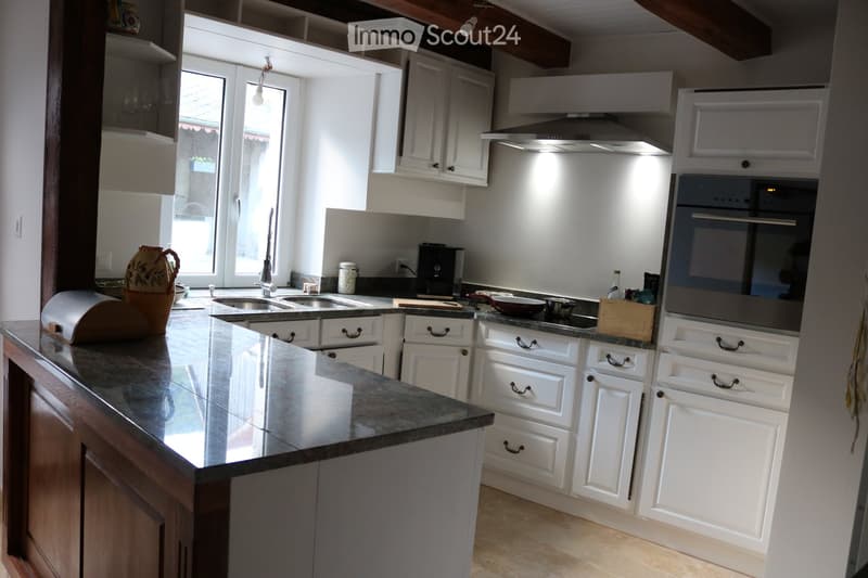 Kitchen. Modern kitchen with white cabinets, granite countertop, stainless steel appliances, and a central island.
