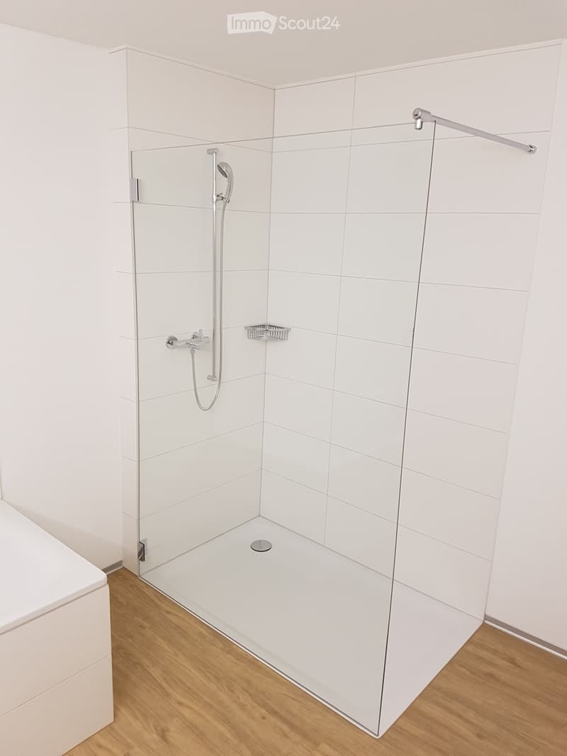 Bathroom. Modern bathroom with a glass shower enclosure, white tiled walls, and wooden floor.